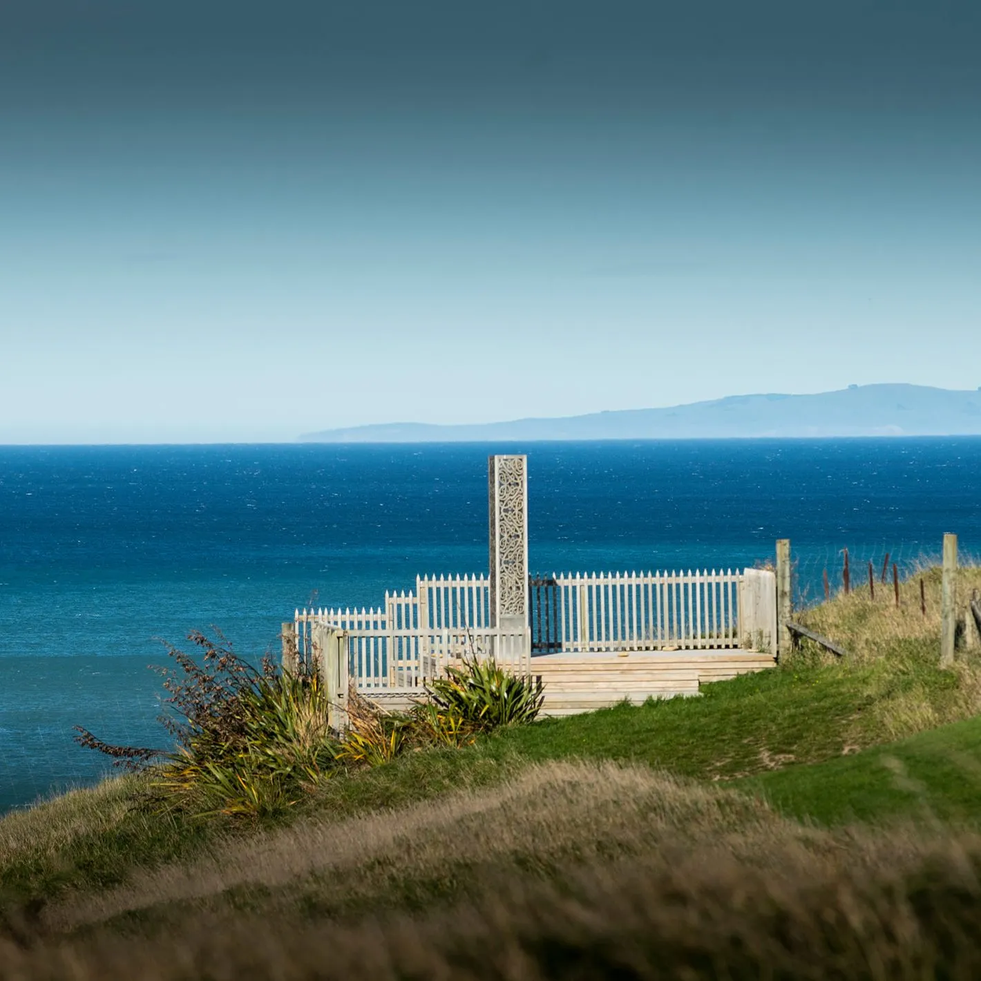 Carved pou and viewing platform above the sea at Tiromoana