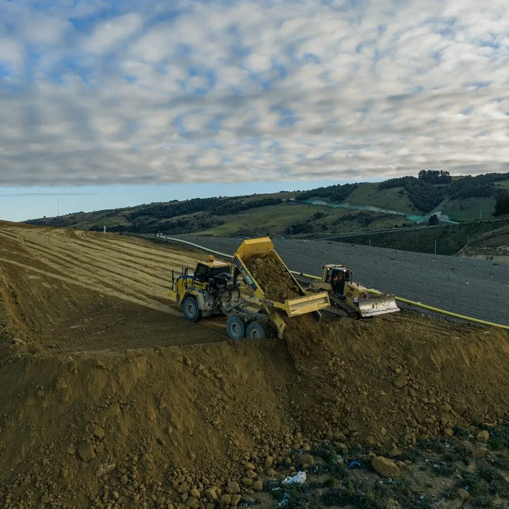 Compactor and dump truck working a landfill cell